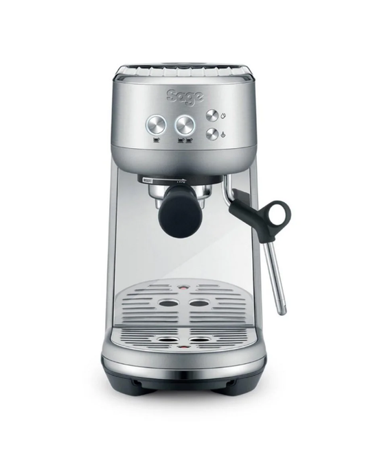 The sleek Sage The Bambino Espresso Machine in silver is perfect for third wave coffee enthusiasts, featuring a central portafilter and right-side steam wand. Its compact design includes control buttons, a cup tray, and an advanced Thermojet heating system for versatile home or office use.