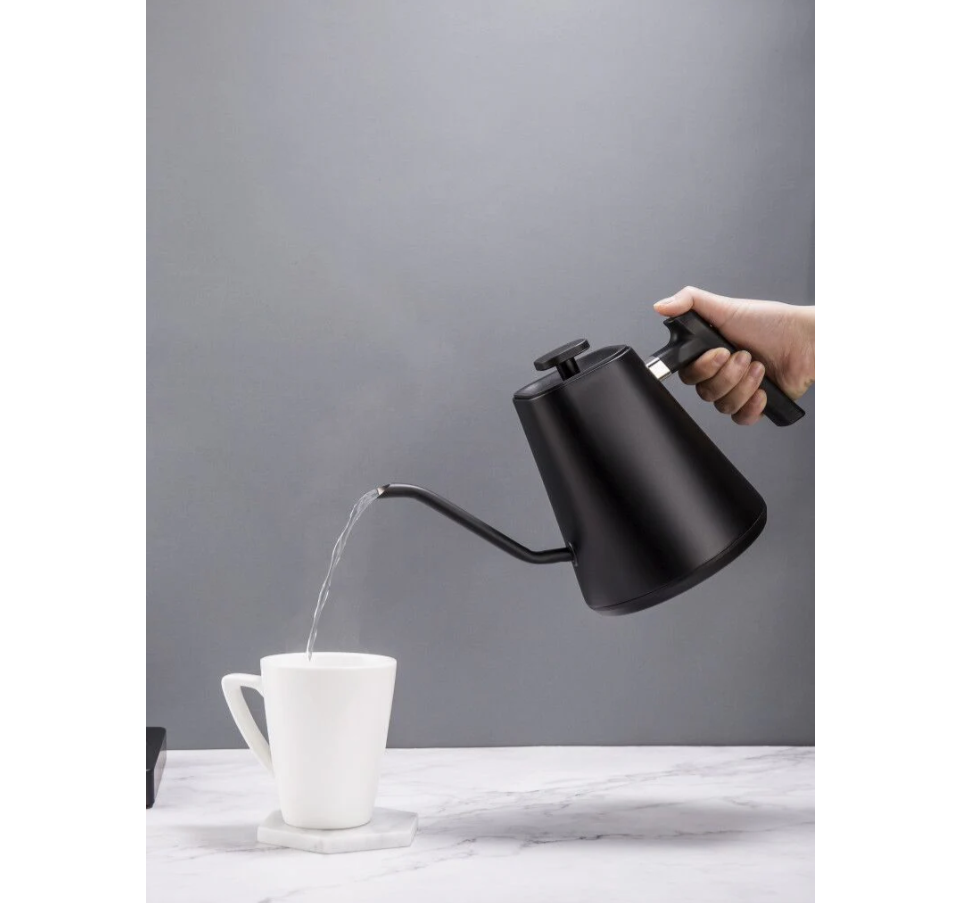 A hand pours hot water from the Felicita Square Temperature Controlled Pour Over Electric Kettle by Felicita into a white mug on a marble surface, set against a plain gray background.